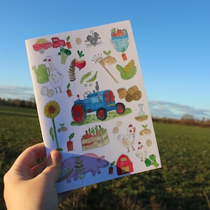 Peut inclure: Une carte blanche avec un tracteur bleu, un camion rouge, une oie, un tournesol, une poule, un cochon et d'autres illustrations sur le thème de la ferme. La carte indique "Fresh is vital" sur une caisse en bois.