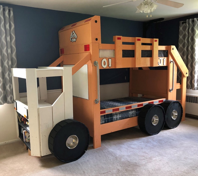May include: A wooden bunk bed shaped like a garbage truck. The top bunk is orange and the bottom bunk is white. The bed has two large black wheels and a smaller black wheel on the front. The bed has a ladder on the side and a railing on the top bunk.