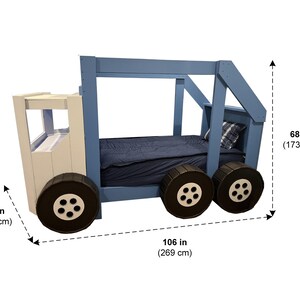 Puede incluir: Una cama de cami&oacute;n de madera azul y blanca con grandes ruedas negras. La cama mide 173 cm de alto, 140 cm de ancho y 269 cm de largo.
