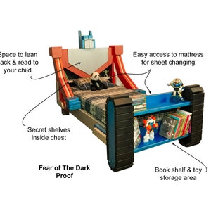 May include: A red, blue, and black wooden bed frame with a built-in bookshelf and toy storage area. The bed frame is designed to look like a robot, with a large head and a chest that opens to reveal secret shelves. The bed frame is also equipped with a built-in nightlight, making it perfect for children who are afraid of the dark. "Fear of The Dark Proof" is written on the bed frame.