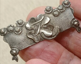 Antike, silberfarbene Brosche aus viktorianischer Zeit mit Kleeblattapplikation und rundum mit kleinen Rosen verziert, Brosche aus einer Sammlung des 19. Jahrhunderts