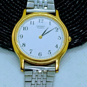 SEIKO Japan vintage 90s women's/men's gold tone Quartz watch V700-8A10, minimalist dial silver tone strap