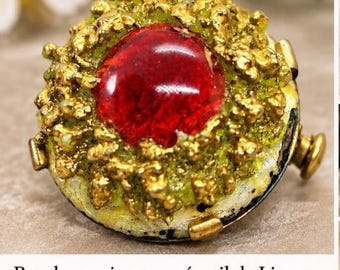 Lovely vintage Limoges enamel brooch, signed on the back; features a central red cabochon surrounded by a raised green and gold design.