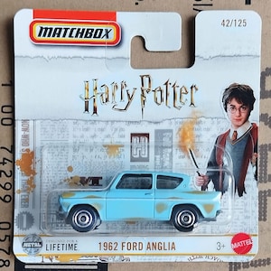 May include: A Matchbox die-cast toy car of the 1962 Ford Anglia, light blue with rust-colored accents. The packaging features the Harry Potter logo and an image of Harry Potter. The car is designed for a lifetime.