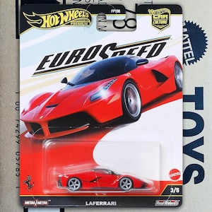 Op de afbeelding: Een Hot Wheels Premium Euro Speed gegoten speelgoedauto. De verpakking toont een rode LaFerrari modelauto met zwarte details. De kaart bevat de tekst "LAFERRARI", "Real Riders" en "3/5". De auto maakt deel uit van de "Car Culture" serie.