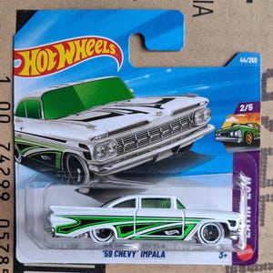 May include: A white '59 Chevy Impala die-cast model car with green and black detailing. The car is part of the Hot Wheels Latin Low series, numbered 44/250. The packaging features a small image of a green car.