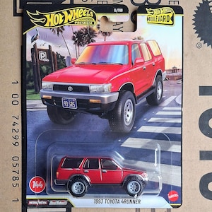 May include: A red 1993 Toyota 4Runner die-cast model car on a Hot Wheels Boulevard card. The card features a picture of the real car on a street with palm trees. The model has black wheels and a license plate that reads "93 SR5".