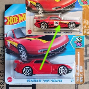 May include: A red '95 Mazda RX-7 Drift/Déraper toy car in its original packaging. The car features the number 95 and a black and white checkered design. The packaging includes the Hot Wheels logo and the text "70s vs 90s".