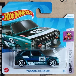 Peut inclure: Une voiture jouet moulée sous pression '73 Honda Civic Custom de couleur bleu sarcelle et bleu. La voiture porte le numéro 73, la marque Honda et les logos Motul. L'emballage comprend le logo Hot Wheels et le texte "Compact Kings."