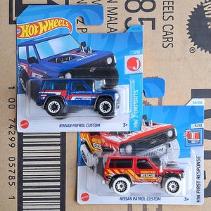 Hot Wheels Nissan Patrol Custom Set de 2 Modelos a Escala de Metal Fundido Azul y Rojo / SUV Todoterreno JDM Coleccionable / Regalo para Coleccionista de Autos, Novio