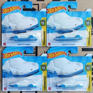 以下が含まれることがあります： 白いポルシェ911カレラに青いアクセントを付けた、ホットウィールのおもちゃの車の4つのパッケージ。各パッケージには、ホットウィールのロゴ、車の名前、番号134/250が記載されています。パッケージは5/5と番号が付けられており、5台の車のセットの一部であることを示しています。