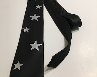 May include: A black silk tie with silver stars printed on it.