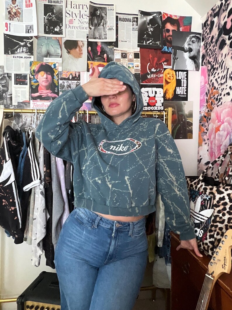 Puede incluir: Una taza de cer&aacute;mica blanca con un asa negra y el texto "But First, Coffee" en un estilo manuscrito. La taza est&aacute; sobre una superficie blanca. La taza mide aproximadamente 10 cm de alto.