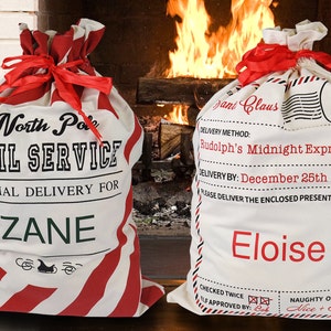 May include: Two red and white striped Christmas gift bags with personalized names. The bag on the left says "North Pole Mail Service Special Delivery for Zane". The bag on the right says "Santa Claus Delivery Method: Rudolph's Midnight Express Delivery By: December 25th Please Deliver the Enclosed Present to: Eloise Checked Twice Elf Approved By: Bob Naughty or Nice? Nice + Sweet".