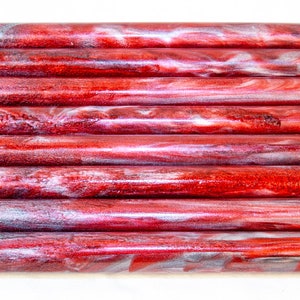 May include: A stack of red and silver acrylic pen blanks with a swirling pattern.