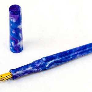 Op de afbeelding: Een blauwe en witte marmeren vulpen met een gouden penpunt en een bijpassende dop.