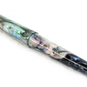 K&ouml;nnte beinhalten: Eine wei&szlig;e Keramik-Tasse mit schwarzem Henkel und dem Text "But First, Coffee" in fetter, schwarzer Schrift. Die Tasse steht vor einem verschwommenen Hintergrund, der eine gem&uuml;tliche Umgebung andeutet.