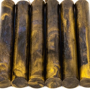 May include: Six cylindrical wooden dowels with a dark brown and gold marbled pattern. The dowels are arranged side by side against a white background. The ends of the dowels are flat and dark brown.