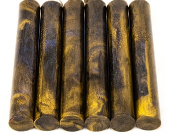 May include: Six cylindrical wooden dowels with a dark brown and gold marbled pattern. The dowels are arranged side by side against a white background. The ends of the dowels are flat and dark brown.
