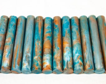 May include: A set of 14 teal and copper colored resin crafting rods. The rods have a marbled effect with swirls of teal, copper, and white.