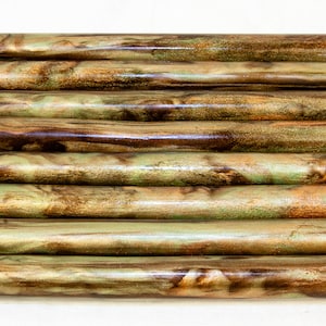 May include: Ten wooden dowels with a marbled pattern in shades of brown, green, and gold.