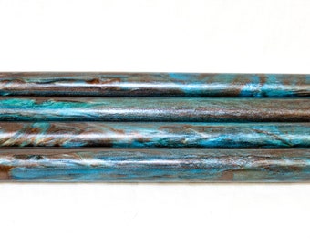 May include: Four wooden dowels with a blue and brown marbled pattern. The dowels are stacked on top of each other.