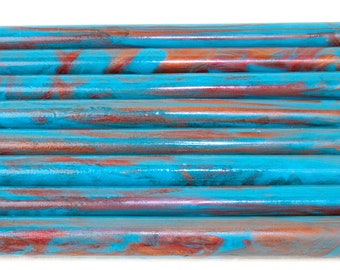 May include: A stack of teal and copper colored wax sticks for sealing envelopes or letters. The wax sticks have a marbled appearance.