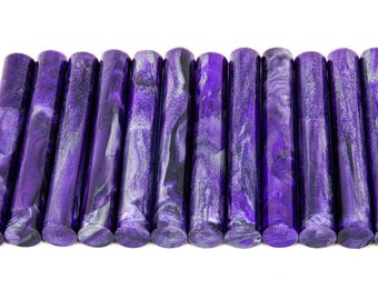 May include: A collection of twelve cylindrical objects with a marbled purple and black pattern. The objects are arranged side by side, showcasing a glossy finish and a rounded base. The color palette is dominated by shades of purple.