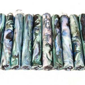 May include: A set of 14 colorful acrylic pen blanks with a marbled pattern in shades of blue, green, black, and white.