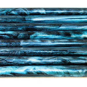 May include: Ten teal and black marbled acrylic pen blanks, stacked in a row.