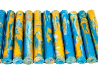 May include: Ten blue, white, and gold marbled acrylic pen blanks. The blanks are cylindrical and have a swirling pattern.