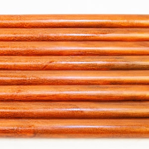 May include: A set of ten wooden dowels, all the same size, arranged in a stack. The dowels are a rich reddish-brown color and have a smooth, polished finish.