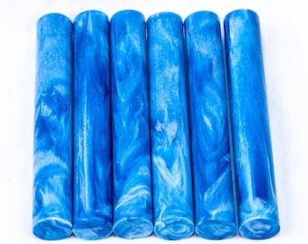 May include: Five blue and white marbled acrylic pen blanks. The blanks are cylindrical and have a swirling pattern of blue and white.
