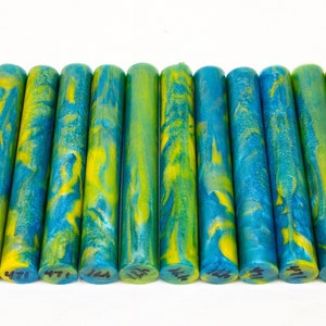 May include: A set of 12 blue and yellow marbled acrylic pen blanks. The blanks are approximately 5 inches long and 1/2 inch in diameter. The marbling pattern is unique to each blank.