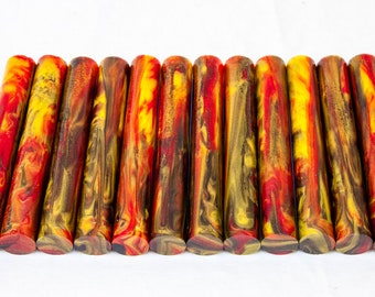 May include: A set of 12 red, yellow, and brown acrylic pen blanks with a marbled pattern. The blanks are cylindrical and have a smooth, polished finish.