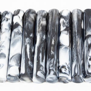 Könnte beinhalten: Ein Satz von zehn schwarzen und weißen marmorierten Acryl-Stiftrohlingen. Die Rohlinge sind etwa 15 cm lang und 1,25 cm im Durchmesser.
