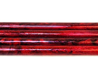 May include: Five red and black marbled acrylic pen blanks. The blanks are stacked on top of each other.