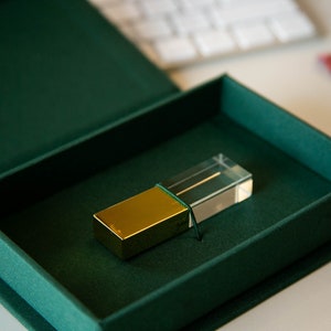 May include: A gold and clear crystal USB drive in a green velvet box.