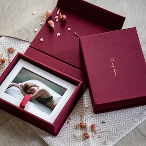 May include: A burgundy fabric-covered box with a white matted photo inside. The box has a gold inscription that reads "To my love".