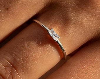 Anel de compromisso delicado e minimalista em prata de lei 925 com diamante de lapidação baguete e zircônia cúbica, perfeito para ela. Anel de noivado elegante e sofisticado em prata com zircônia cúbica.