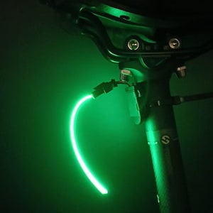 Puede incluir: Una taza de cerámica blanca con un asa negra y el texto "But First, Coffee" en negro, con una fuente de estilo manuscrito. La taza está sobre una superficie blanca.