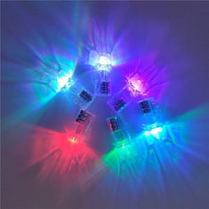 May include: A collection of small, transparent plastic LED lights, radiating beams of red, green, blue, and purple light. The lights are arranged in a circular pattern, producing a colourful and dynamic display. The lights are likely battery-operated.