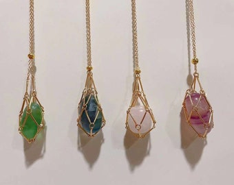 May include: Four gold necklaces with different colored gemstones encased in a gold cage pendant. The gemstones are green, blue, pink, and purple.