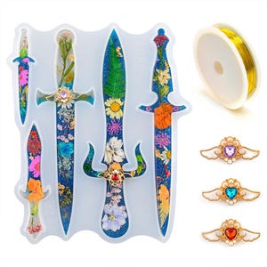 May include: A translucent silicone mold featuring four distinct dagger shapes filled with colorful pressed flowers and blue glitter. Included are a spool of gold wire and three decorative metal wing-shaped accents with heart-shaped gems.