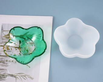 May include: A green resin flower-shaped dish with gold flakes inside. A white silicone mold of the same shape is shown next to it.