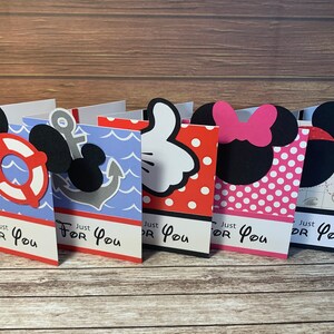 May include: A collection of five folded greeting cards with various designs. The cards feature nautical themes, Mickey Mouse hands, polka dots, and maps. Each card has a black and white design with the text "Just For You".