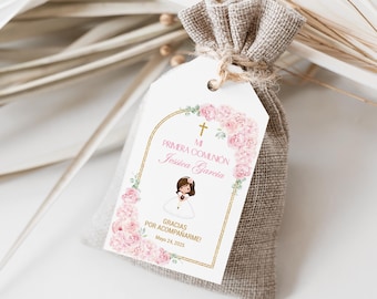 Può includere: Un sacchetto bianco per bomboniere con un'etichetta rosa e dorata che dice "Mi Primera Comunión Jessica Garcia" con una croce e un disegno floreale. L'etichetta dice anche "Gracias por acompañarme!" e "Mayo 24, 2023".