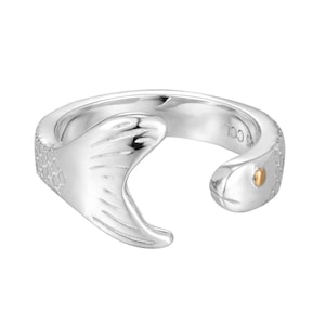 May include: A silver-toned ring in the shape of a snake, with a textured body and a gold-colored eye. The snake's head curves around the finger, creating a unique and stylish design. The ring is set against a plain white background.