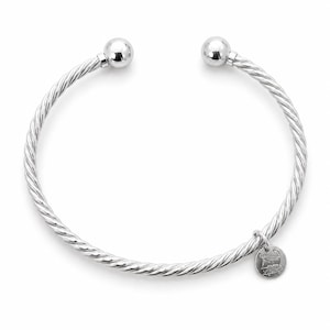 May include: A silver-toned open cuff bracelet featuring a twisted cable texture and two polished spherical end caps. A small, circular metal charm is attached to the band, engraved with the text Cape Cod Lifestyle and a map outline of the region.