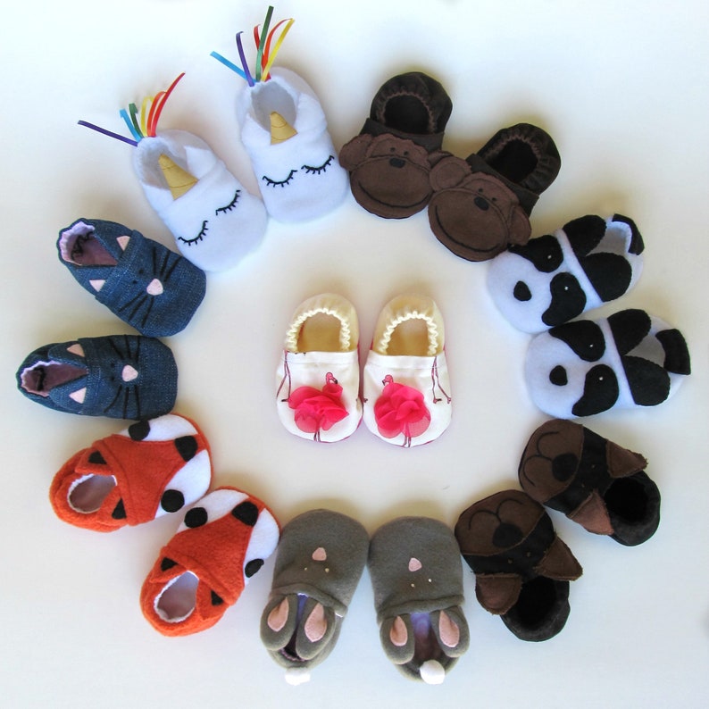May include: A collection of 12 colorful baby shoes with various animal and whimsical designs. The shoes are made of soft fabric and have a variety of colors, including blue, pink, red, white, black, and brown.